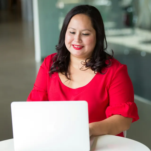 Die Beispielperson Nina Albers arbeitet an ihrem Laptop